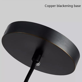 A circular black base with a copper finish, evoking the elegance of ART DECO, called the "All Copper Modern Pendant Light" by Morsale. A sleek black cable gracefully descends from its center, set against a minimalist gray backdrop ideal for displaying sophisticated pendant lights or contemporary LED bulbs.