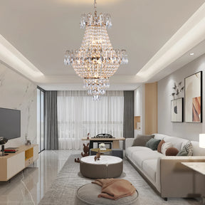 A modern living room showcases a Morsale French Empire Crystal Chandelier and sleek pendant lights. It features a white sofa, round coffee table, and wall-mounted TV. Natural light filters through sheer curtains, enhancing the elegant design.