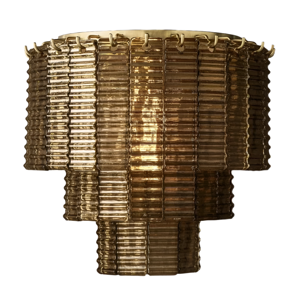 The Palermo Smoke Crystal Wall Sconce by Chandelier Style features ribbed glass panels with a textured appearance in a warm, amber hue. Designed with tiered, cylindrical shapes framed in brass and adorned with crystal accents, this vintage-style wall sconce emits a soft, warm light from within. Luxurious and elegant, it embodies a retro aesthetic that adds charm to any space.
