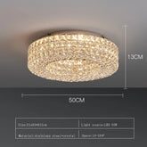 The Bacci Crystal Ceiling Light Fixture by Morsale, featuring LED bulbs, is elegantly installed on the ceiling, casting a warm glow. The illumination dances off the crystals, producing a sparkling effect. The room boasts modern decor with dark walls and offers a view of the dining area below.