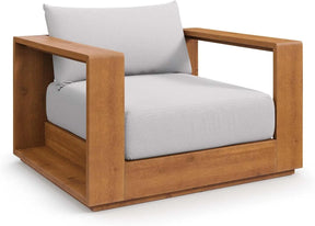 Discover Morsale's Tahoe Acacia Wood Outdoor Patio Chair, showcasing US craftsmanship. With a minimalist design, it features thick light gray cushions and broad wooden armrests. This stylish piece perfectly combines comfort and contemporary flair.