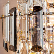Close-up of the Morsale Lazzo Crystal Wall Sconce featuring rectangular prisms and small round accents, highlighting contemporary lighting. The sconce’s glass reflects light, creating a captivating display of colors and reflections against a softly blurred background.