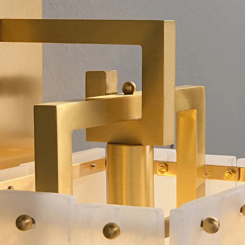 Close-up of the Burren Marble Sconce by Morsale, featuring modern gold metal geometric squares and frosted panels with round gold fasteners. Compatible with LED bulbs for efficient lighting in contemporary spaces.