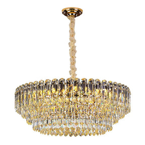 The Morsale Gio Crystal Chandelier is a luxurious lighting fixture featuring multiple tiers of hanging crystals and a gold-colored design. This modern chandelier is equipped with LED bulbs to emit a warm, elegant glow and is elegantly suspended from a gold ceiling mount.