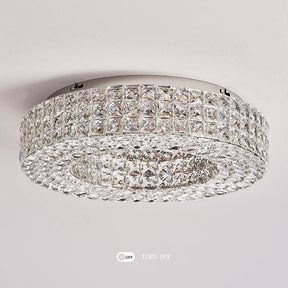 The Bacci Crystal Ceiling Light Fixture by Morsale exudes modern elegance with its circular design and silver base. It features two concentric rings adorned with small square crystals, enhancing its luxurious appeal. This sophisticated crystal lighting piece also includes convenient "OFF" and "TURN OFF" buttons.