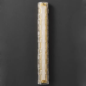 The Postmodern Luxury Glass & Copper Wall Sconce by Morsale features a modern cylindrical design with elongated textured glass, casting a warm golden light that exudes elegance when mounted on a dark wall.