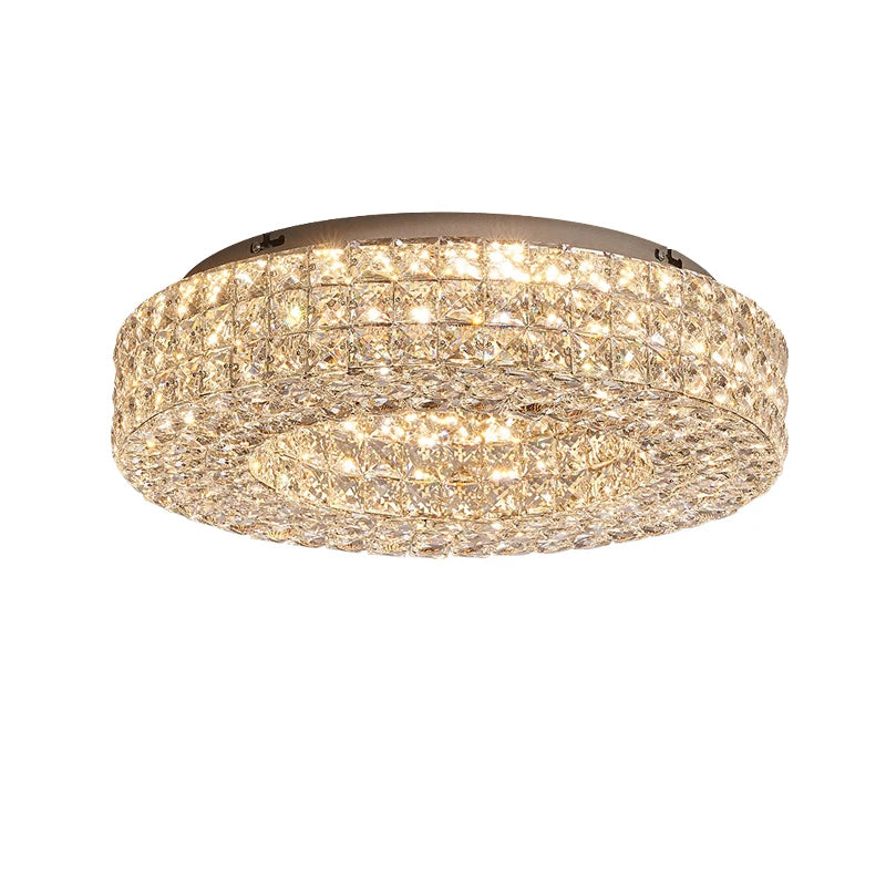 The Bacci Crystal Ceiling Light Fixture by Morsale is a circular, flush-mount design that features LED bulbs and numerous small, sparkling crystals. These crystals create a dense, shimmering pattern around the light, lending it a modern style with an elegant and luxurious appearance.