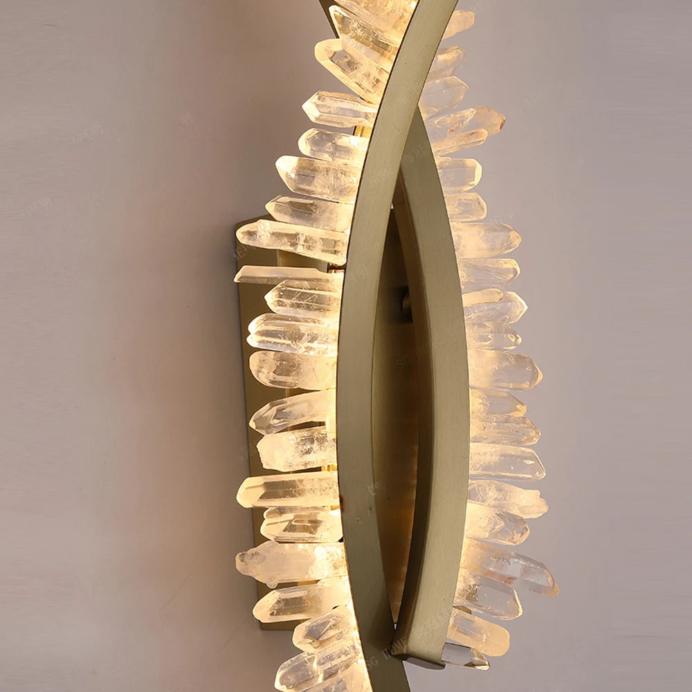 The Morsale Orion Crystal Wall Sconce is a modern LED lamp featuring a sleek, curved gold metal frame adorned with clear crystals, creating a radiant illuminated effect to beautifully enhance any space.