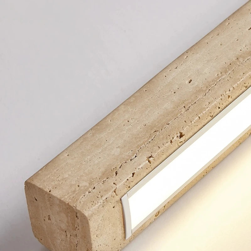 A minimalist, modern cord pendant light fixture from Morsale.com hangs from a high ceiling in a stylish, contemporary room. The Natural Travertine LED Kitchen Light Fixture features a long, rectangular wooden beam with LED bulbs suspended by two thin, nearly invisible cables. The room has clean lines and subtle beige tones.