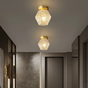 Two Palermo Ceiling Lights by Morsale, featuring a geometric design and a gold finish, hang from the ceiling of a modern hallway. They are equipped with energy-efficient LED bulbs that cast warm light. The neutral-colored walls reflect the modern style, with doors lining both sides of the corridor.