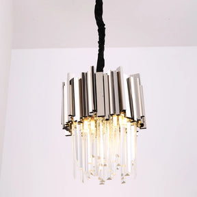 The Gio Crystal Kitchen Light Fixture by Morsale.com hangs from the ceiling, featuring a design of vertical stainless steel rods and suspended K9 Crystal prisms. The crystals catch the light, creating a sparkling effect.