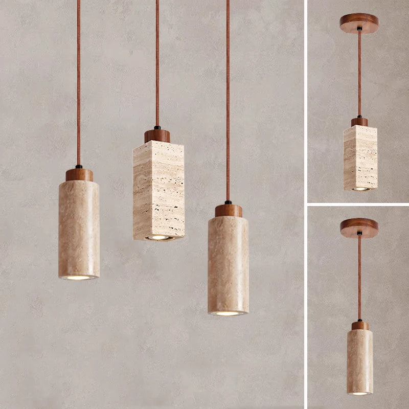 Three Natural Travertine Pendant Lights from Morsale.com with cylindrical beige shades hang from the ceiling. The central light, elegantly crafted from travertine, showcases a square, stone-like shade, while the two on either side feature round, smooth shades. All lights include LED bulbs and matching brown cords for a cohesive look.