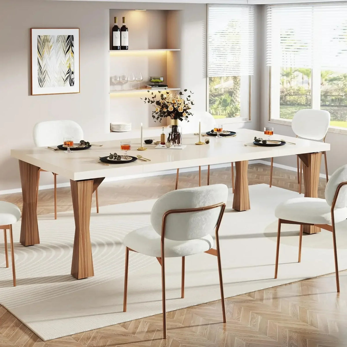 A modern dining room showcases the Morsale Boston 70" Modern Dining Table, a sleek white rectangular table with wooden legs, paired with five cushioned chairs. It's elegantly set with candles, glasses, plates, and complemented by art pieces, two wine bottles, and a plant on shelves as sunlight streams through blinds.