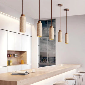 Three Natural Travertine Pendant Lights from Morsale.com with cylindrical beige shades hang from the ceiling. The central light, elegantly crafted from travertine, showcases a square, stone-like shade, while the two on either side feature round, smooth shades. All lights include LED bulbs and matching brown cords for a cohesive look.