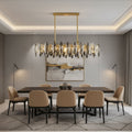 Modern dining room with a dark wood table, eight beige chairs, geometric rug, abstract wall art, two floor lamps, and the Morsale Lazzo Crystal Dining Chandelier hanging above the table.