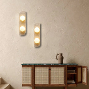 The Natural Travertine Stone LED Wall Lamp by Morsale.com features a modern vertical rectangular base and three evenly spaced, illuminated spherical bulbs that cast a warm, ambient LED light against a neutral background. The base, reminiscent of Art Deco design, is crafted from stone-like travertine with a smooth, curved edge on the left side.