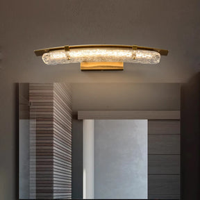 On a dark wall, the Copper & Glass Modern LED Wall Sconce by Morsale stands out with its contemporary curved design and textured glass shade. Its bronze finish enhances the cozy ambiance created by the soft glow of LED lighting, while the copper material adds an elegant touch to the room.