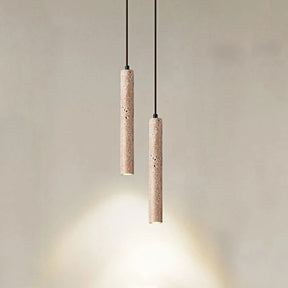 A sleek, cylindrical pendant light from Morsale.com, the Natural Travertine Modern Pendant Light, hangs from the ceiling, casting a warm glow over a small potted plant. The background features a beige wall and a piece of wooden furniture with a light-colored cushion. The scene exudes a minimalist, cozy ambiance.