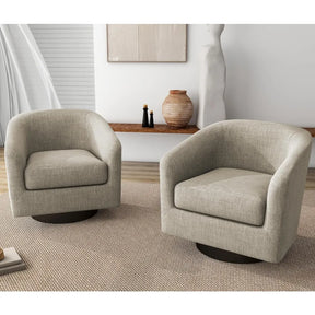 In a minimalist room, two modern beige Swivel Barrel Accent Chairs by Morsale sit on a textured rug. A wooden shelf with a sculpted vase and decor is behind them. Light filters through the window with white blinds, casting soft shadows as the chairs rest on their 360° swivel bases.