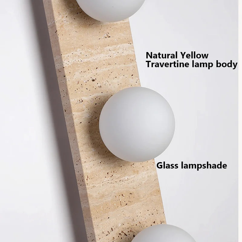 The Natural Travertine Stone LED Wall Lamp by Morsale.com features a modern vertical rectangular base and three evenly spaced, illuminated spherical bulbs that cast a warm, ambient LED light against a neutral background. The base, reminiscent of Art Deco design, is crafted from stone-like travertine with a smooth, curved edge on the left side.