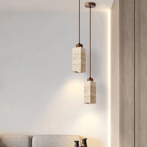 Three Natural Travertine Pendant Lights from Morsale.com with cylindrical beige shades hang from the ceiling. The central light, elegantly crafted from travertine, showcases a square, stone-like shade, while the two on either side feature round, smooth shades. All lights include LED bulbs and matching brown cords for a cohesive look.