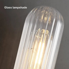 Close-up of a lit glass lampshade with vertical grooves, emitting a warm glow. The text "Palermo 23" Brass Wall Sconce Light by Morsale" is visible in the upper left corner. The soft, ambient illumination merges beautifully with the Modern Design and sophisticated touch of Elegant Lighting.