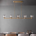Ventoux linear crystal and brass chandelier over a dining table