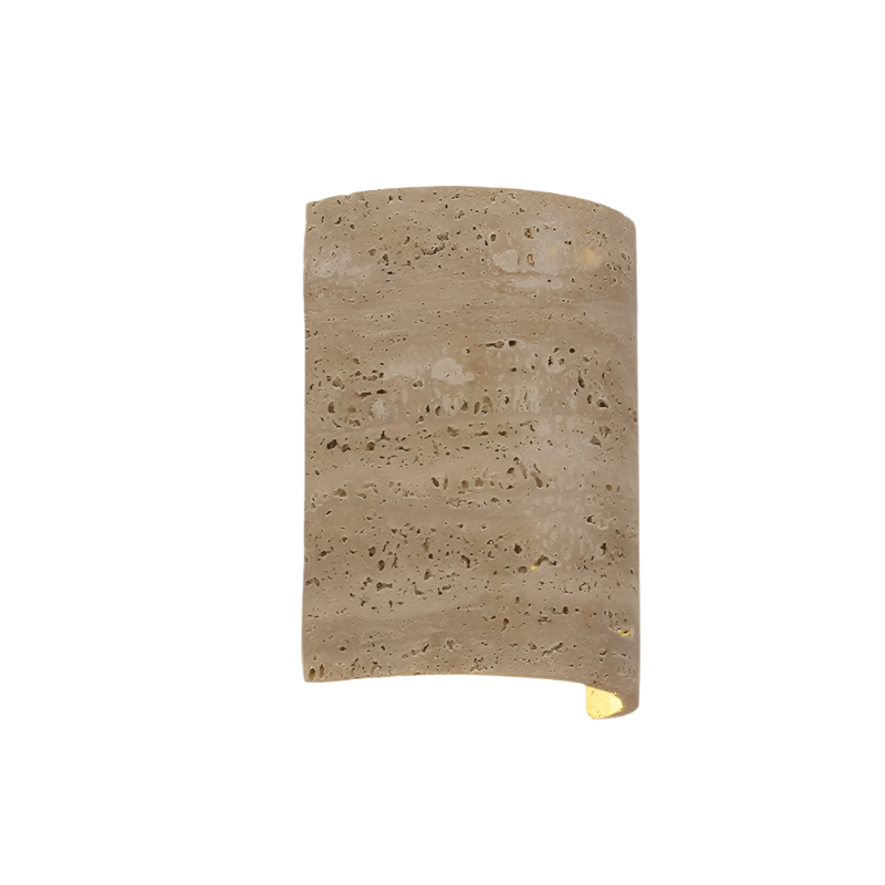 A Natural Travertine Art Deco Wall Lamp from Morsale.com, crafted from beige, porous stone and shaped into a cylinder, is mounted on a white wall. The light radiates softly from both the top and bottom, generating an ambient glow around the fixture that accentuates its ART DECO design.