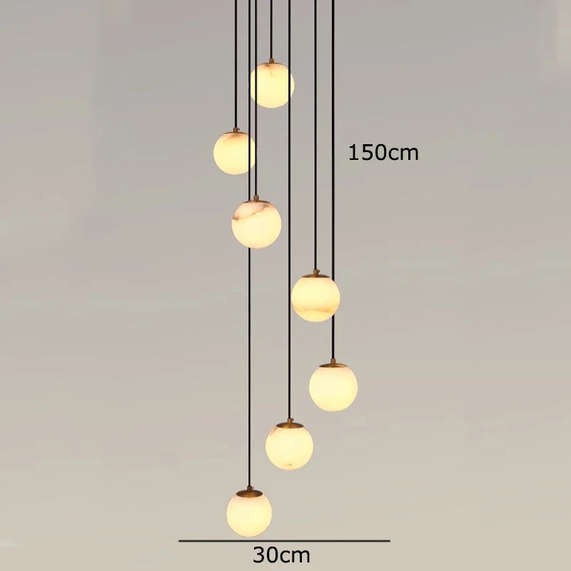 
                  
                    Eight spherical LED lights of the Brighton Marble Ball Chandelier by Morsale hang at varying heights (up to 150 cm drop, 30 cm spread), providing a warm glow and modern style against a plain backdrop.
                  
                