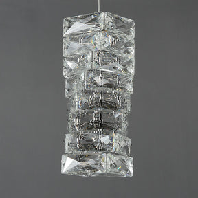 A Bacci Crystal Pendant Light Fixture made of stacked rectangular handmade crystals that reflect and refract light, hanging against a gray background from Morsale.com.