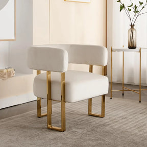 A pair of Morsale Velvet Accent Chairs with white upholstery and gold metal legs enhances a stylish room. A nearby small table holds a vase of green branches, completing the neutral palette and minimalist decor.