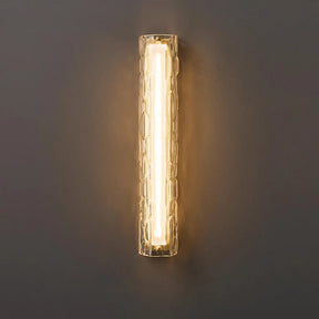 The Postmodern Luxury Glass & Copper Wall Light by Morsale is a contemporary lighting fixture with a cylindrical shape, featuring a textured glass cover and copper accents, which emits a warm, gentle glow against dark surfaces.