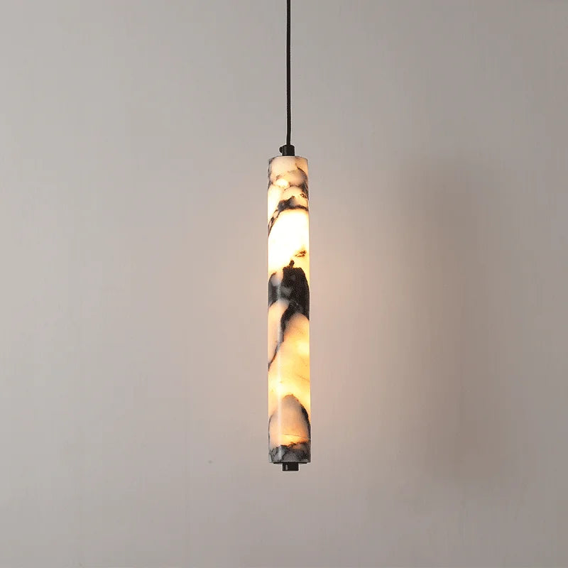 
                  
                    The Morsale Valmont Marble Cylinder Pendant Light showcases a white and gray marble-patterned shade on a black cord, adding modern LED elegance to any light-colored wall.
                  
                