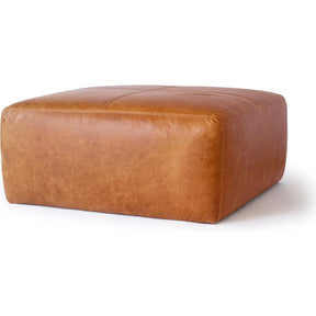 The Morsale Leather Ottoman in Cognac Tan features a smooth surface with visible stitching, rounded edges, and a flat top. Ideal as seating or a footrest, this large square piece is proudly made in the USA, chemical-free, and combines style with safety.