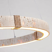 Close-up of the Natural Travertine Modern Light Fixture by Morsale, a circular chandelier made of textured stone-like material. It features a rustic appearance with rope details and emits a warm glow from LED bulbs in its interior edge.