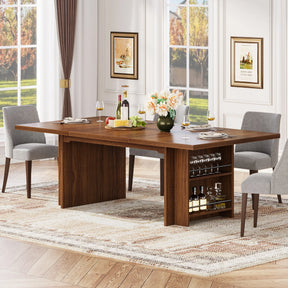 The Morsale Bristol 63" Dining Table with Storage is set with four gray chairs, wine glasses, a fruit platter, and a flower vase. A built-in shelf holds bottles and glasses. Large windows reveal a sunny day outside, and two framed pictures enhance the setting's charm.