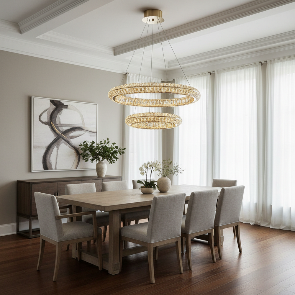 
                  
                    A modern dining room features a light wood table, eight upholstered chairs, two Bacci Modern Chandeliers by Morsale.com, abstract wall art, potted plants, and sheer white curtains covering tall windows.
                  
                