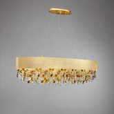 The Avani Crystal Dining Room Chandelier by Morsale.com is a modern luxury chandelier with a sleek, circular design. It features an arrangement of amber and clear crystals and gold accents hanging below a wide, gold band. The chandelier is suspended from the ceiling by thin wires, set against a plain gray background.