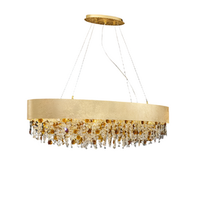 The Avani Crystal Dining Room Chandelier by Morsale.com is a modern luxury chandelier with a sleek, circular design. It features an arrangement of amber and clear crystals and gold accents hanging below a wide, gold band. The chandelier is suspended from the ceiling by thin wires, set against a plain gray background.