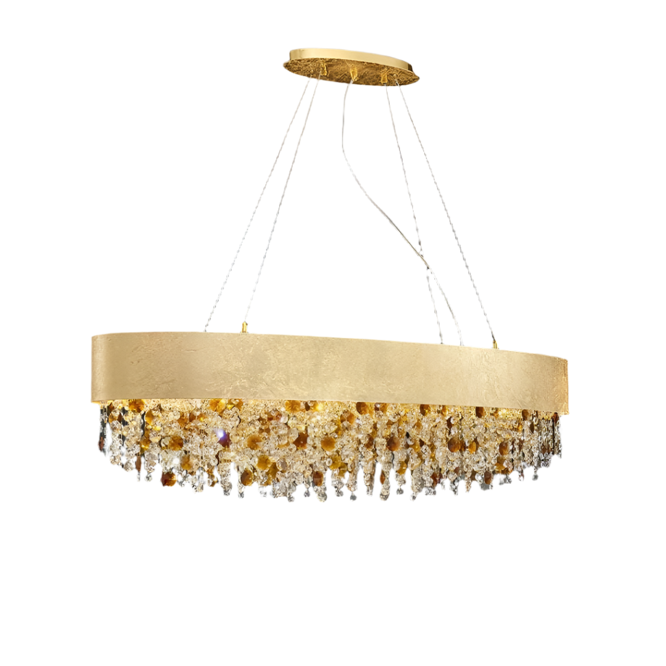 The Avani Crystal Dining Room Chandelier by Morsale.com is a modern luxury chandelier with a sleek, circular design. It features an arrangement of amber and clear crystals and gold accents hanging below a wide, gold band. The chandelier is suspended from the ceiling by thin wires, set against a plain gray background.