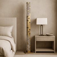 Decorative floor lamp with crystals next to a nightstand with a lamp and bowl in a bedroom setting.