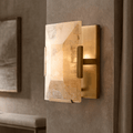 Brookhill Calcite Wall Sconce with a single natural calcite prism on an iron frame, glowing softly on a beige wall.