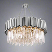 The Gio Stainless Steel & Crystal Modern Chandelier by Morsale.com hangs from a silver chain, showcasing a circular design. Crafted from premium materials, it features silver rectangular metal panels on the top and multiple crystal-like hanging pieces that create a cascade effect. The elegant lighting fixture is turned on, casting a warm glow.