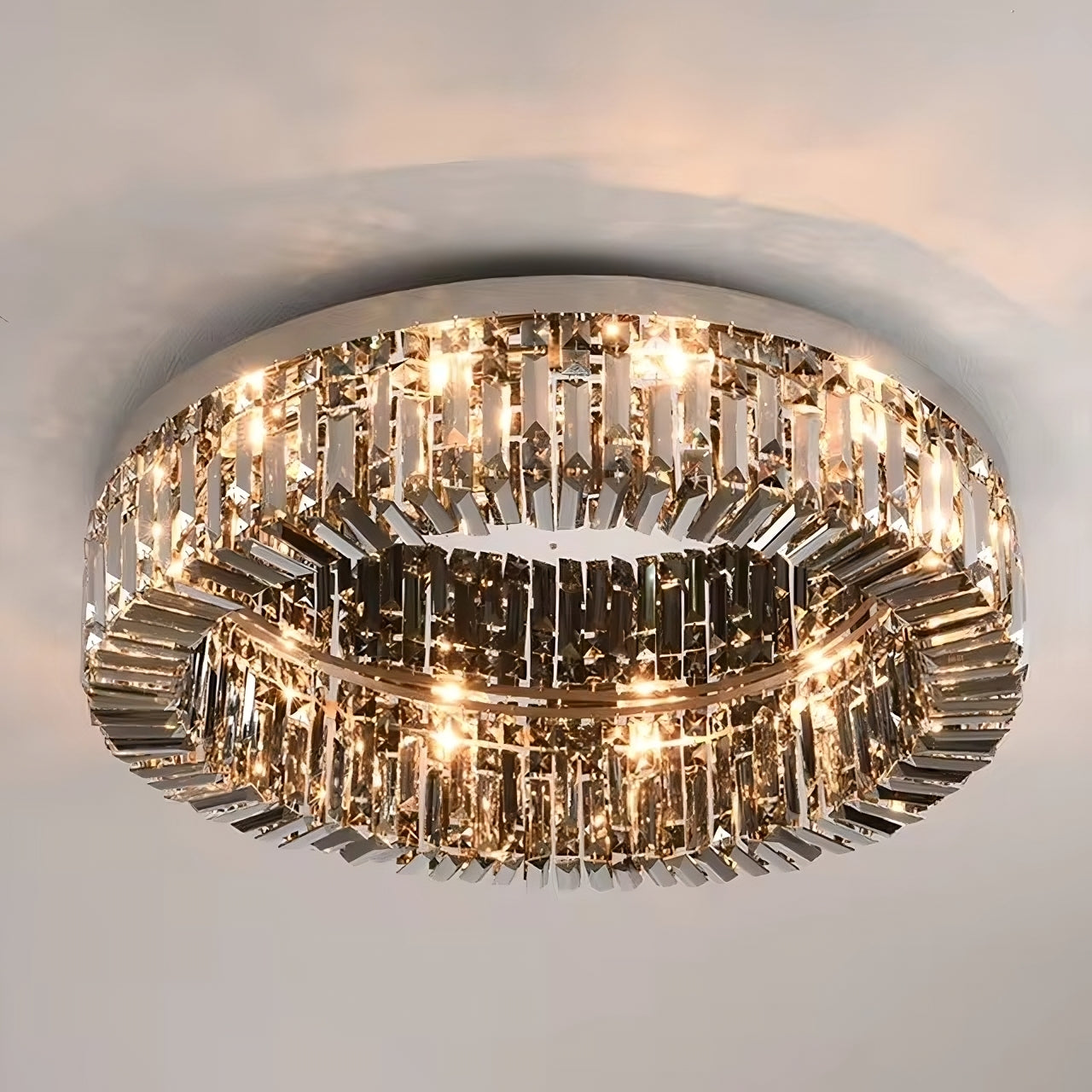 The Specchio Smoke Grey Crystal Ceiling Light by Morsale.com is a contemporary circular chandelier adorned with numerous small, rectangular glass or crystal pieces arranged around the ring. This sophisticated ceiling light emits a warm, glowing illumination, enhancing any space with an ambiance of luxurious modern decor.