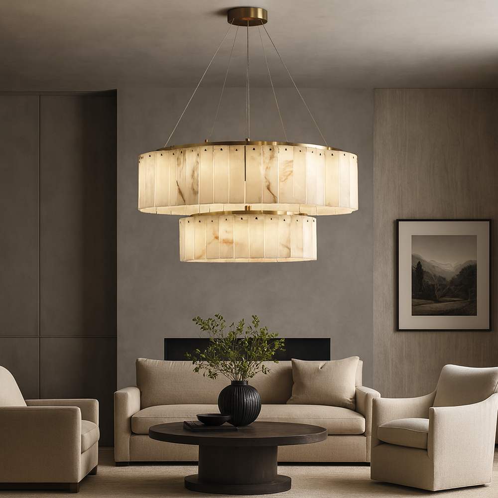 A modern living room with neutral-toned sofas, a round dark coffee table with a black vase of greenery, wall art, and the Solenne Two-Tier Marble Chandelier by Morsale.com making a statement overhead.