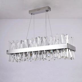 The Calvi Crystal Dining Room Light Fixture by Morsale.com hangs from the ceiling by two thin wires. Featuring K9 crystal prisms arranged in a fringe pattern, this modern rectangular chandelier reflects light and creates a sparkling effect against a plain white background. This LED light fixture adds a touch of elegance to any space.