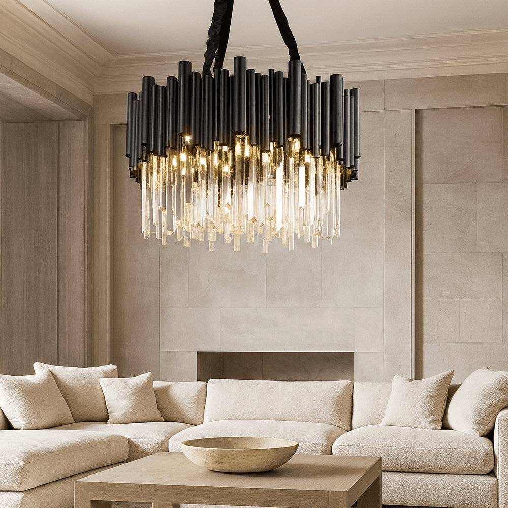 A modern living room features a large cream sectional, a light wood coffee table with a round bowl, and the Vigo Crystal Chandelier by Morsale.com—an eye-catching stainless steel piece with black and gold rods and exposed bulbs, set against beige walls.