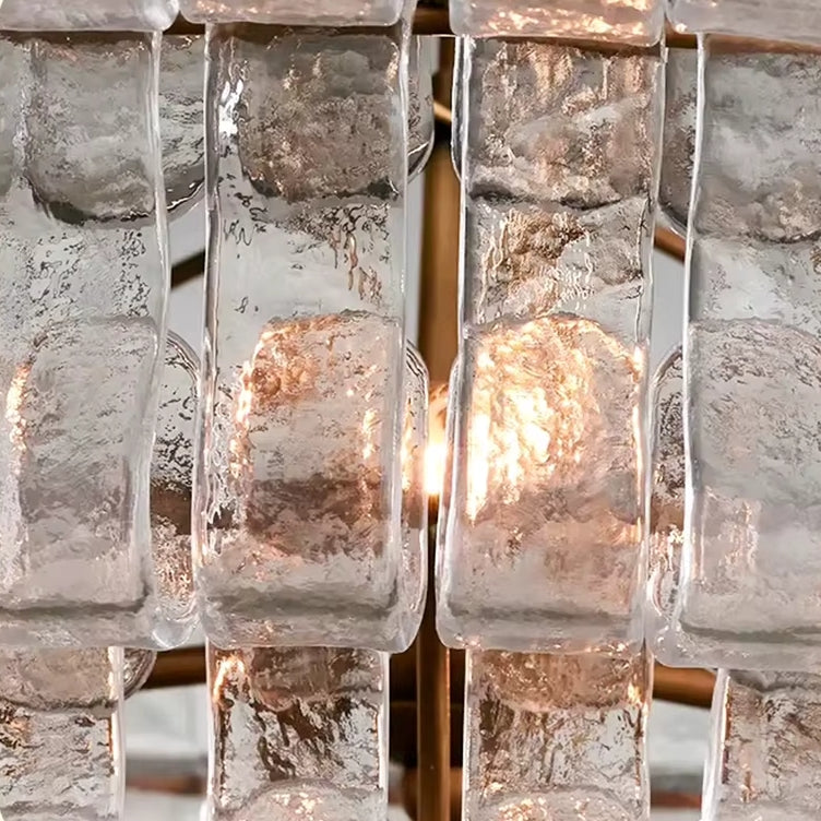 
                  
                    Close-up of the Riviera Flush Mount by Morsale, featuring textured rectangular glass pieces with a central light source that creates a warm glow and highlights the intricate glass details.
                  
                