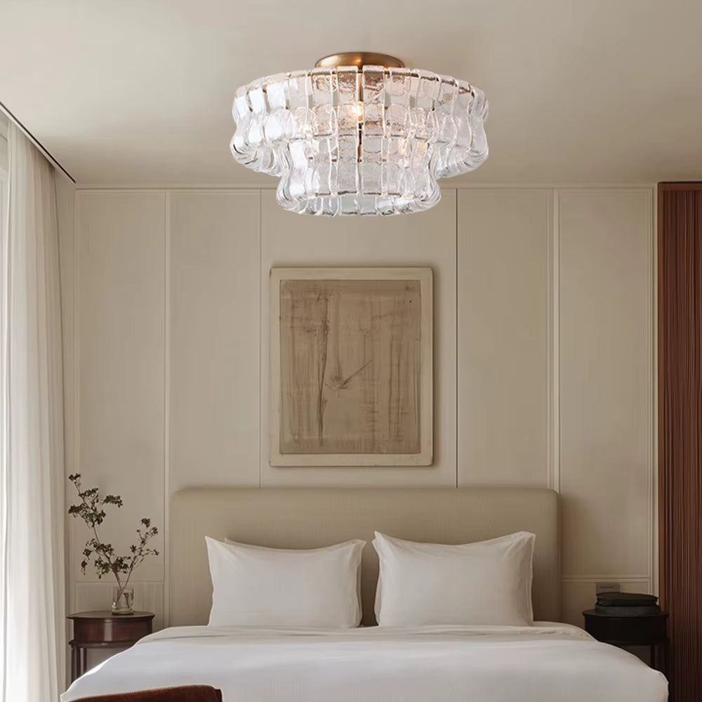 
                  
                    A modern bedroom features a low bed with white bedding, minimal wall art, and a Morsale Riviera Flush Mount chandelier. A vase with branches rests on the bedside table beneath the elegant ceiling light.
                  
                