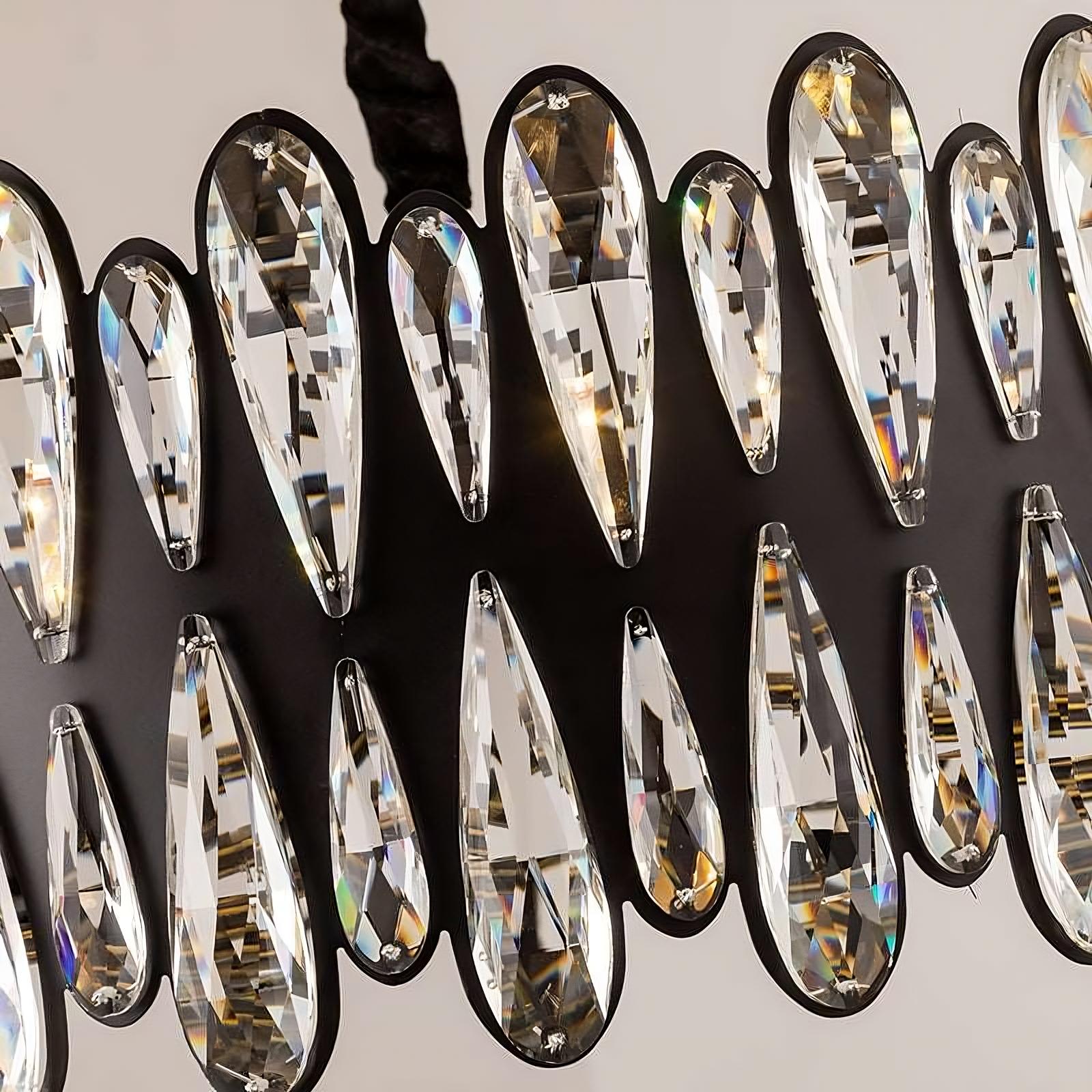 Close-up of the Stacy Richards 30" Modern Chandelier by Morsale.com, showcasing an array of elongated, teardrop-shaped crystals. Mounted on a dark stainless steel frame, each piece reflects light from discreet LED bulbs, creating a shimmering effect. The neutral background highlights the brilliance of this exquisite chandelier.